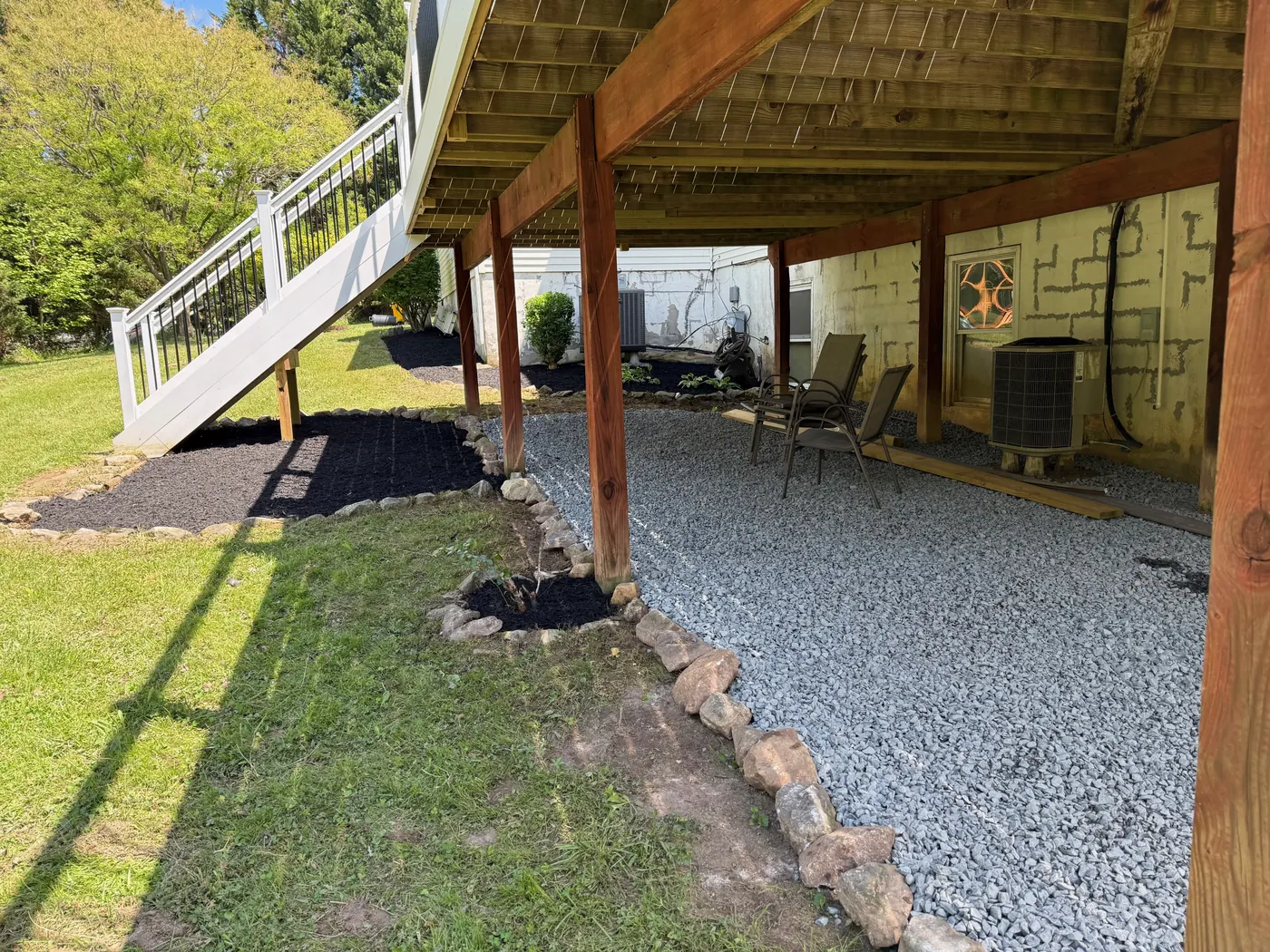 Gravel and mulch border finished under a wooden deck