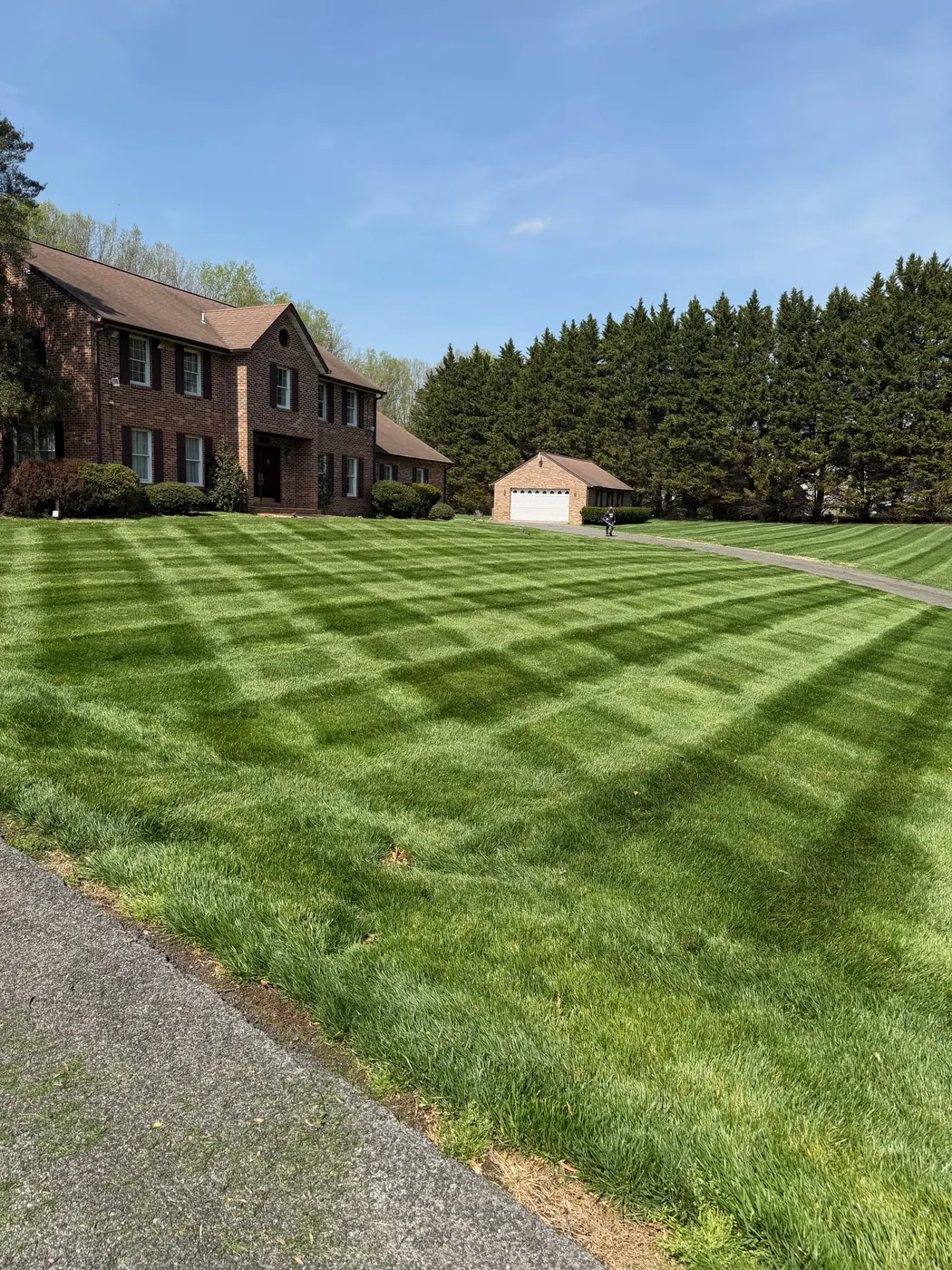 Freshly mowed striped lawn in front of a brick home in Maryland